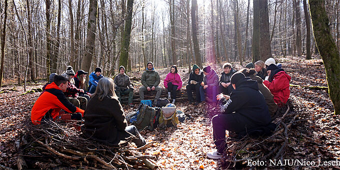 Juleica: Besprechung im Wald - Foto: NAJU/Nico Lesch Die Teilnehmenden sitzen im Kreis im winterlichen Wald